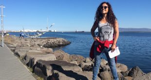 İzlanda'da deniz kıyısındaki kayalıklarda poz veren bir kadın