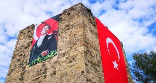 Tarihi kale kulesinde asılı Türk bayrağı ve Atatürk posteri