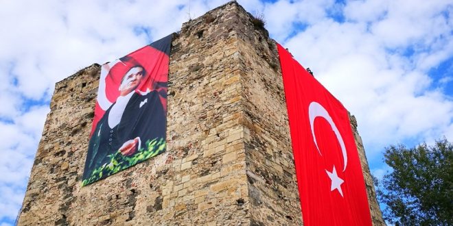 Tarihi kale kulesinde asılı Türk bayrağı ve Atatürk posteri