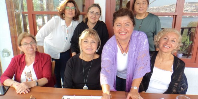 Restoranda doğum günü pastası önünde poz veren kadınlar