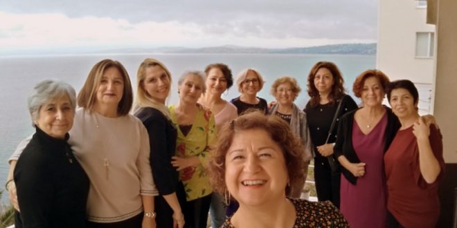 Deniz manzaralı odada bir arada poz veren kadınlar