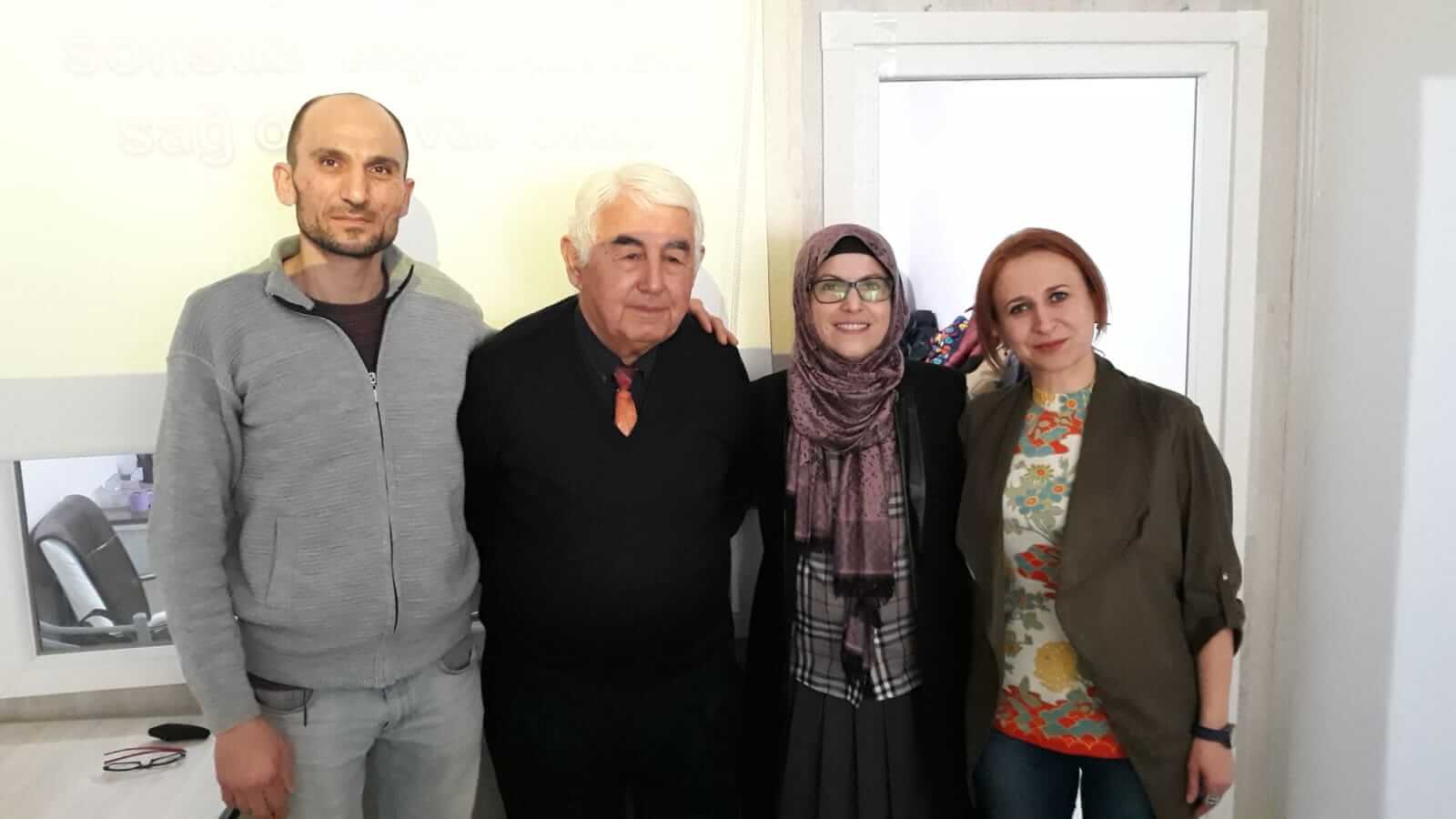 Dernekte yan yana poz veren dört kişi.