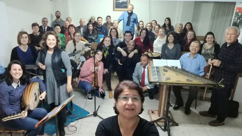 Sinop Belediye Konservatuvarı'nda enstrümanlı müzik grubuyla selfie çeken bir kadın.