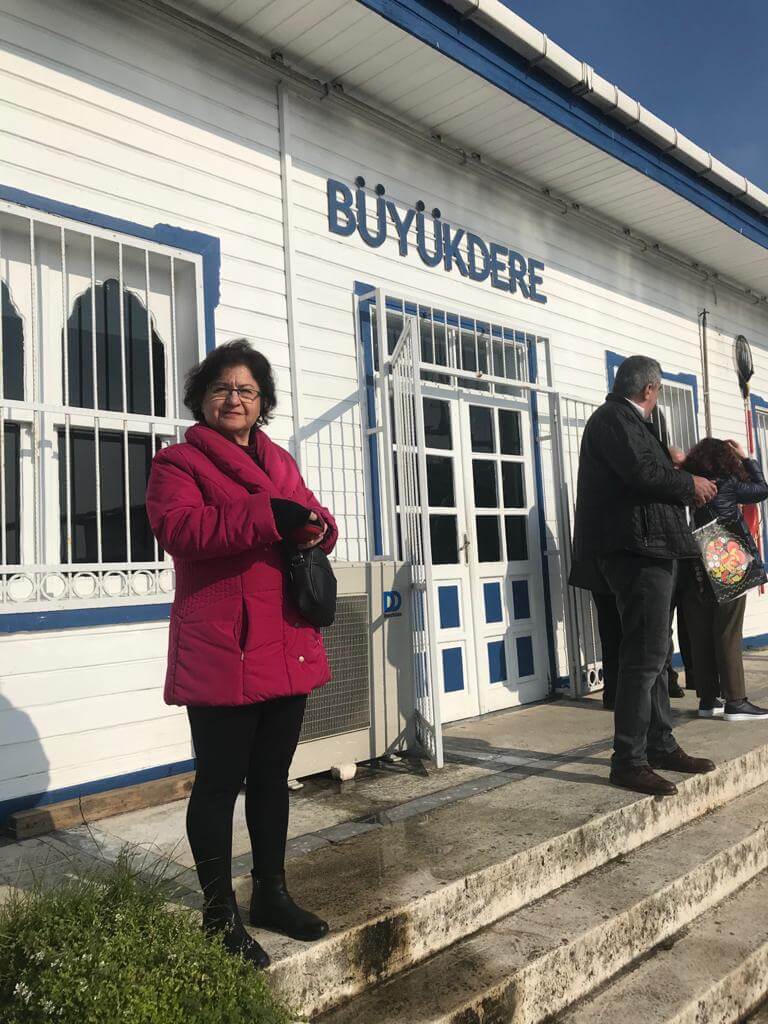 Tarihi bir binanın önünde duran bir kadın.