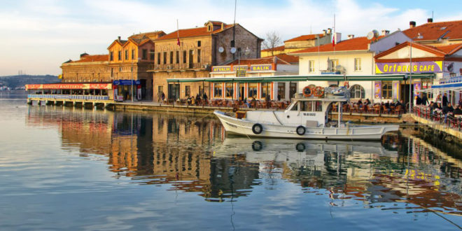 Ayvalık limanındaki tekneler ve renkli bina cepheleri.