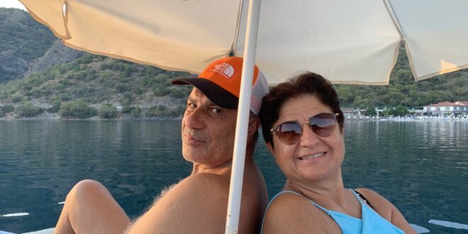 Fethiye'de teknede şemsiye altında oturan bir çift