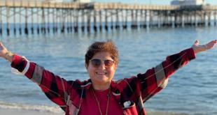 Amerika Balboa Island sahilinde kollarını açan kadın