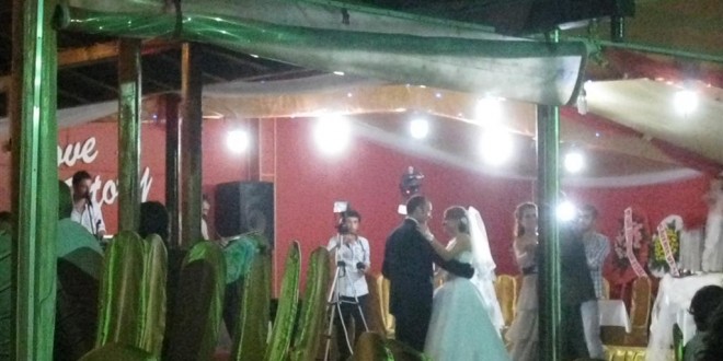 Düğün salonunda dans eden gelin ile damat ve çekim yapan kameraman