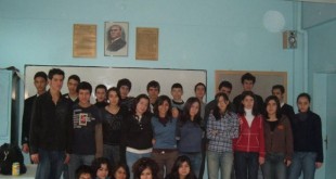 Sınıfta duvar önünde toplu halde poz veren genç öğrenciler