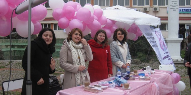 Pembe balonlarla süslü stantın önünde duran dört kadın