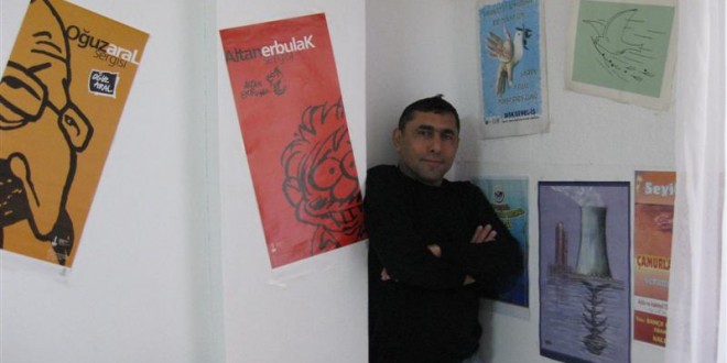 Afişlerle dolu sınıf duvarının önünde kollarını kavuşturmuş duran erkek